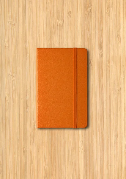 在木制背景上隔离的橙色闭锁笔记本电脑模型 — 图库照片