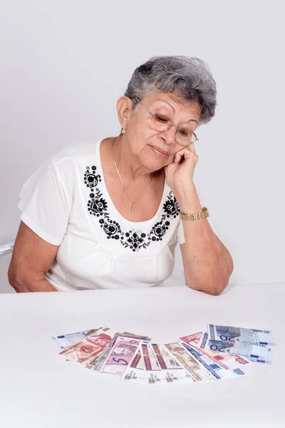 眼鏡をかけた老女がお金を見て — ストック写真