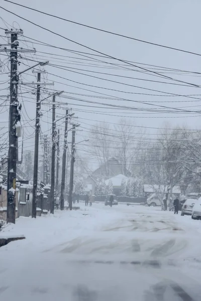 罗马尼亚雪地道路与房屋 汽车和电线杆的低视角 — 图库照片