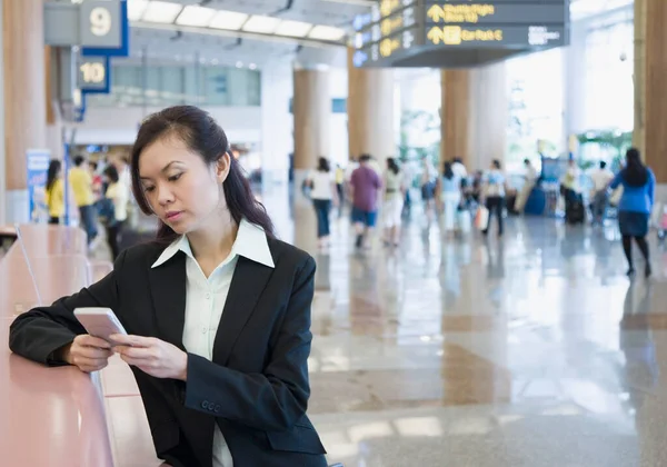 Geschäftsfrau Mit Einem Tragbaren Gerät Auf Einem Flughafen — Stockfoto