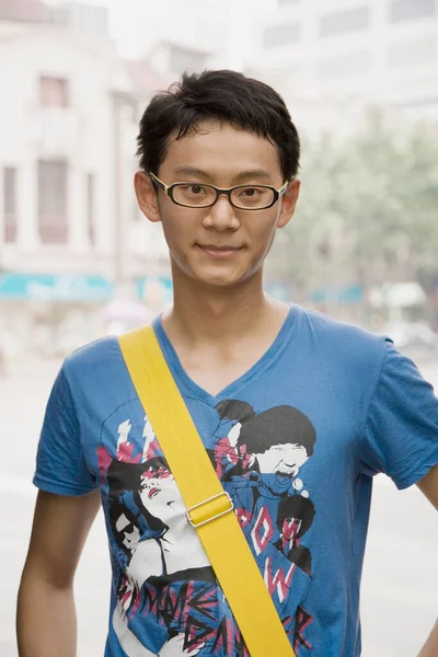 リュックを背負った若いアジア系男性の肖像画とコーヒーの袋です — ストック写真