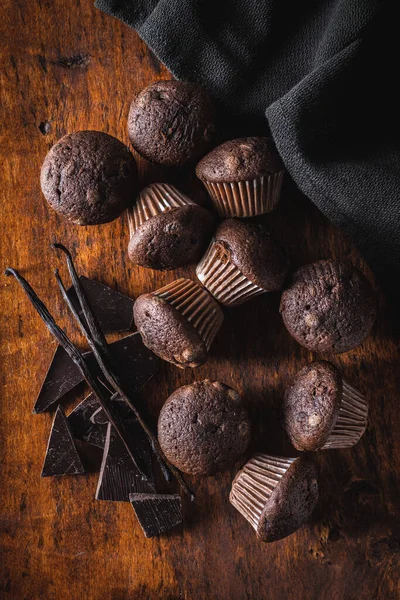 초콜릿 초콜릿과 바닐라 꼬투리가 어두운 컵케이크 위에서 — 스톡 사진
