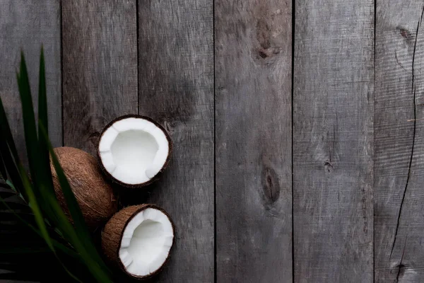 Разбитые Кокосы Сером Деревянном Фоне Пальмовым Листом Белый Кокосовый Орех — стоковое фото
