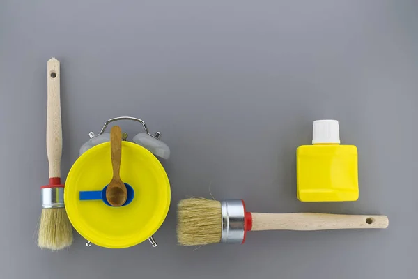 创意Diy 装饰或翻新背景与两个干净的刷子和一个五颜六色的黄色警钟与工具形成灰色的边界与复制空间 — 图库照片