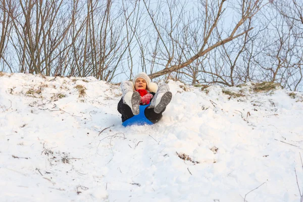 Ένα Κορίτσι Κυλάει Μια Χιονισμένη Τσουλήθρα Ενώ Κάθεται Ένα Πλαστικό — Φωτογραφία Αρχείου