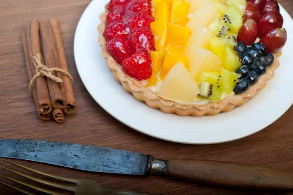 배경에 과일을 곁들인 맛있는 집에서 케이크 — 스톡 사진