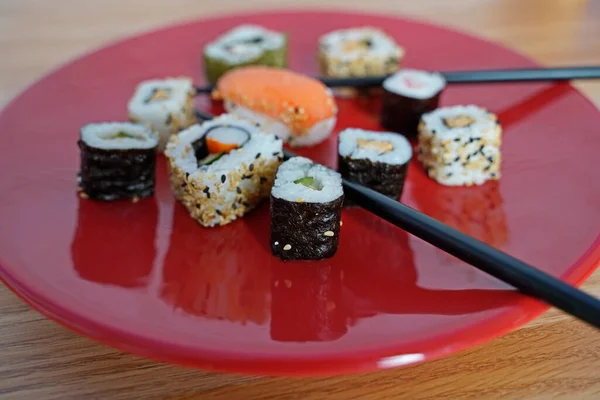 Sushi Rendezett Egy Piros Tányéron Evőpálcikákkal — Stock Fotó