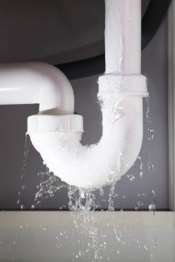 Close-up Of Water Is Leaking From The White Sink Pipe clipart