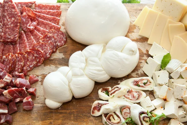意大利腊肠和干酪切板上的干酪形辫子 — 图库照片
