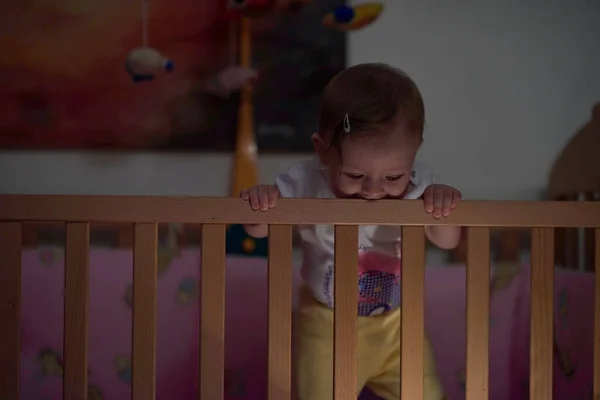 かわいい1歳の赤ちゃんがベッドでおもちゃで遊んでいる間に最初の一歩を踏み出し 歩くことを学ぶ — ストック写真