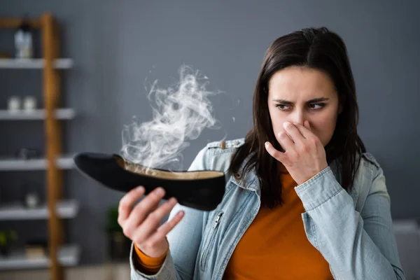 女人闻到臭鞋子的味道 脚汗和臭味 — 图库照片