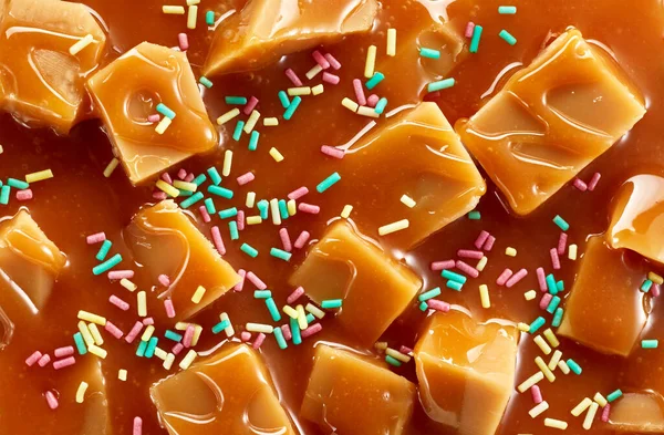 Close up Splash of caramel sauce with fudge candies.Top view of sweet treat portion isolated on white backgroundmel sauce with fudge candies of caramel sauce with fudge candies. Top view of sweet treat portion