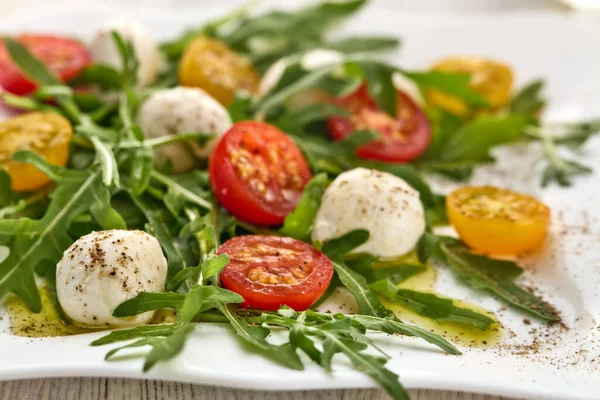 Fehér Tál Mozzarella Sajt Diétás Salátával Cseresznyeparadicsom Arugula Levél Asztali — Stock Fotó