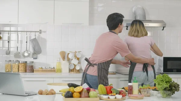 快乐的亚洲美丽家庭夫妇夫妇在厨房里一起烹调蔬菜沙拉 那个男人溜进去假装爱抚那个女人的腰部 健康食品概念 — 图库照片