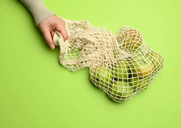 Hand Halten Beige Stofftasche Mit Grünen Äpfeln Auf Grünem Hintergrund — Stockfoto
