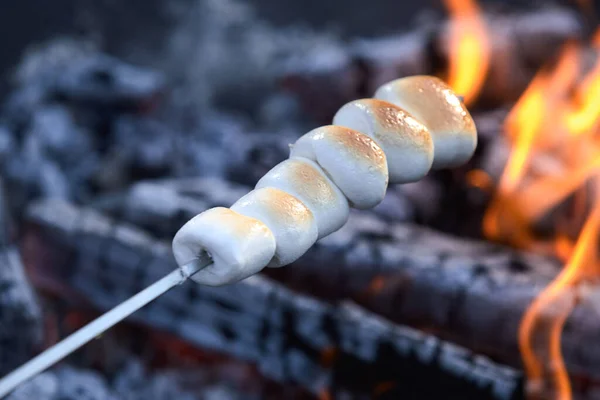 在烤火的炽热的煤块上 在一个倾斜的煤块上涂上褐色的软融化的烤棉花糖 — 图库照片