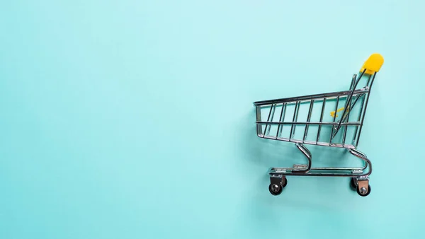蓝色背景的购物车 顶视图或平铺 超市的购物车作为销售 购物狂的概念 带有文本或设计的复制空间 消费者社会趋势 — 图库照片