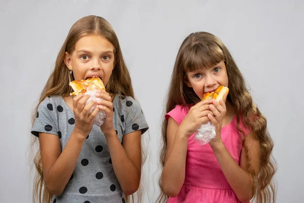 2人の空腹の女の子がパンを食べ フレームを見て — ストック写真