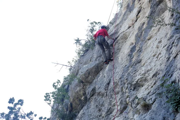 Hombre Está Trepando Una Pared Roca Con Cuerda Roja —  Fotos de Stock