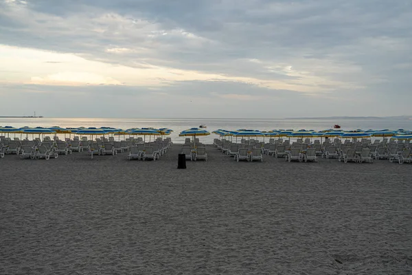 Opuszczona Wieczorna Plaża Leżaki Parasole Plażowe Stoją Rzędu — Zdjęcie stockowe