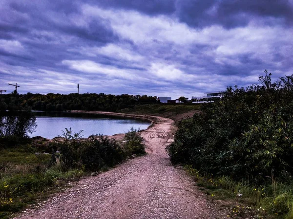 Küçük Deniz Üzerinde Karanlık Bulutlu Gökyüzü Yol Bitkiler Renkli Gökyüzü — Stok fotoğraf