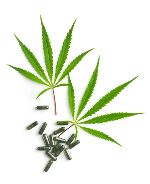 マリファナ大麻の葉と白い背景に隔離された錠剤 — ストック写真