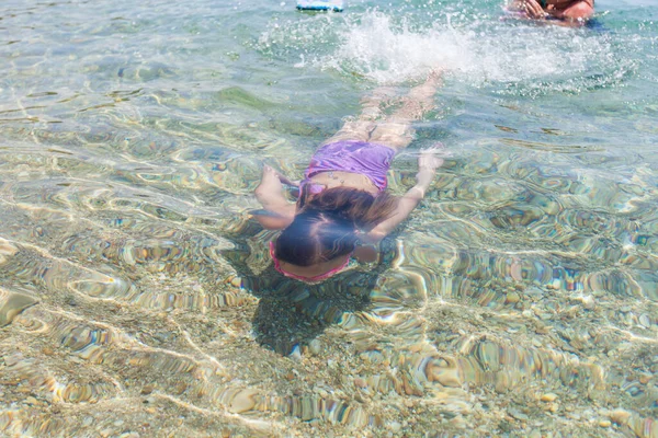 夏休みの子供の活動 海で泳ぐ小さな女の子 トップビュー — ストック写真
