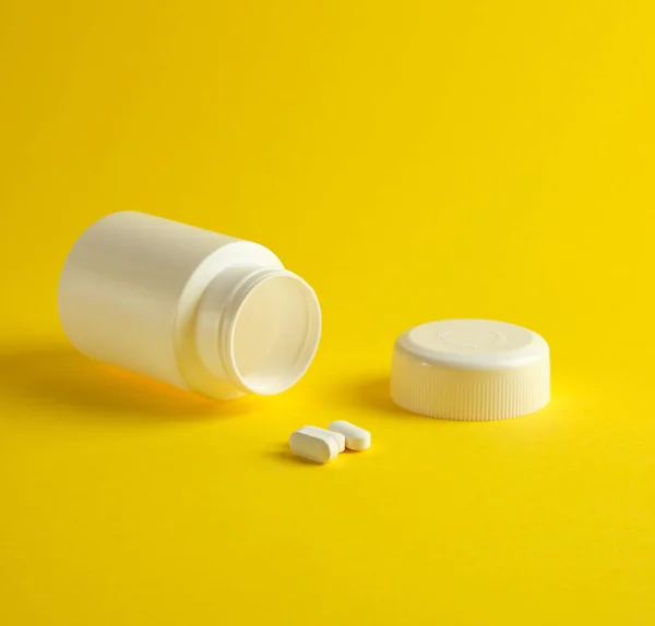 Frasco Plástico Branco Aberto Para Medicamentos Pílulas Ovais Fundo Amarelo — Fotografia de Stock