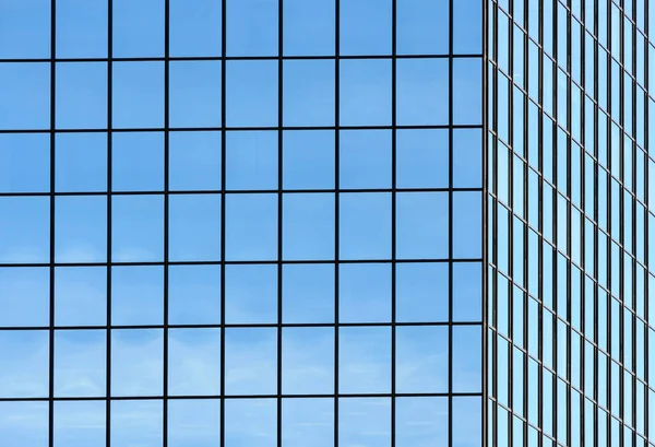 スカイを反映した正方形のグリッドパターンのオフィスビルの窓のコーナー — ストック写真