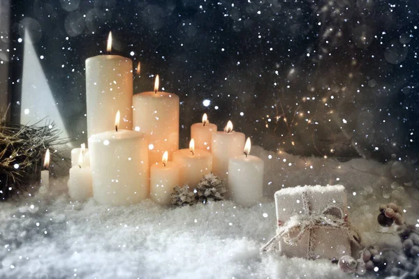 雪の降る冬の夜にろうそくを燃やすクリスマスの装飾 — ストック写真