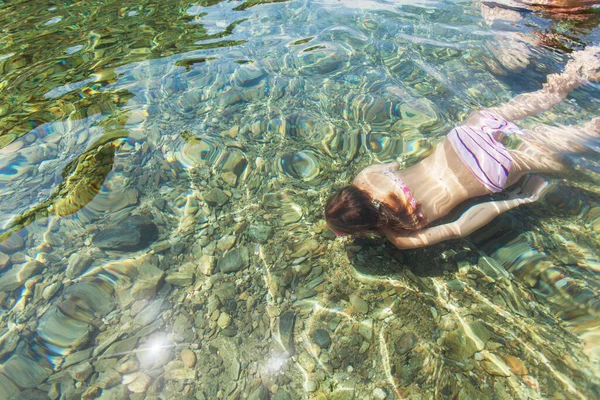 海の中で水中を泳ぐ少女のトップビュー — ストック写真