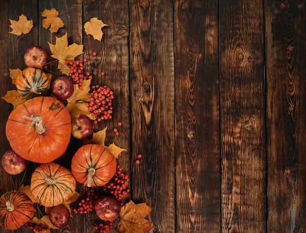 カボチャと木のテーブルの上の葉を持つ秋の背景 — ストック写真