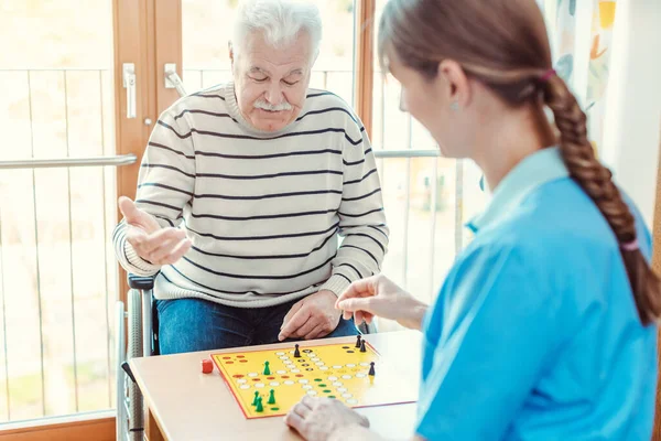 Krankenschwester Und Senior Altenheim Spielen Gemeinsam Ein Brettspiel — Stockfoto