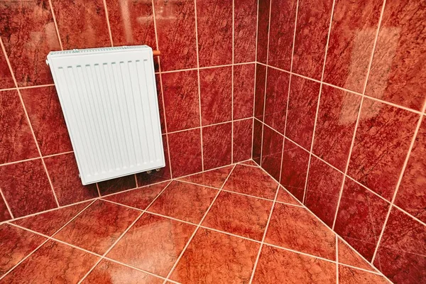 带有小暖气散热器地面反射光的小红瓷砖浴室 — 图库照片