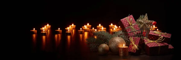 Bevásárlókocsi Ajándékdobozok Karácsonyi Dekoráció Égő Gyertyákkal Fenyőággal Fekete Háttéren Fénymásoló — Stock Fotó