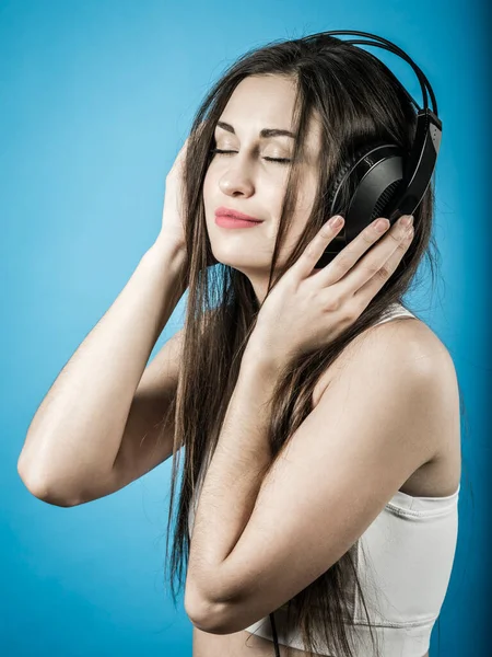 stock image Photo of a beautiful young woman having fun listening to music with large headphones.