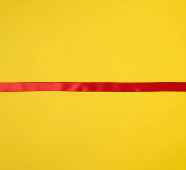 Κόκκινη Μεταξωτή Κορδέλα Κίτρινο Φόντο Εορταστικό Φόντο Τόπος Για Κείμενο — Φωτογραφία Αρχείου