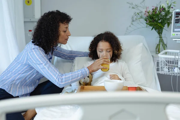 Zijaanzicht Van Gemengde Race Moeder Voeden Haar Zoon Sinaasappelsap Bed — Stockfoto