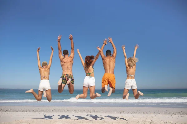 Vista Trasera Del Grupo Diversos Amigos Saltando Juntos Playa — Foto de Stock