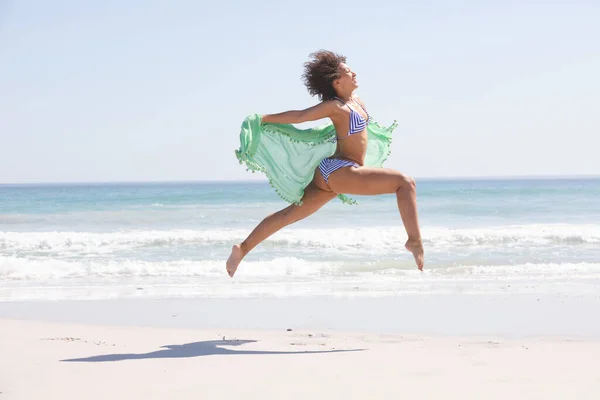 Vista Lateral Mujer Afroamericana Bikini Con Bufanda Saltando Playa — Foto de Stock