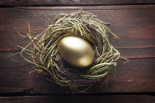 Gouden Een Nest Een Houten Achtergrond — Stockfoto