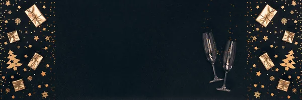 黄金のクリスマスの装飾 ギフトボックス 黒の背景にシャンパンフルート トップビュー コピースペース グリーティングカード 招待状 広告のデザイン要素 超広角パノラマバナーの背景 — ストック写真