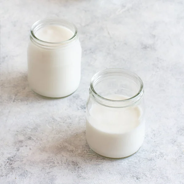 Fermented drink kefir in small bottles and kefir grains on a white background close up