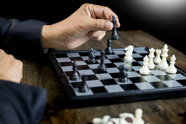 商人移动棋子人物在竞争棋盘游戏中的手进行发展分析 战略理念管理或领导理念 — 图库照片