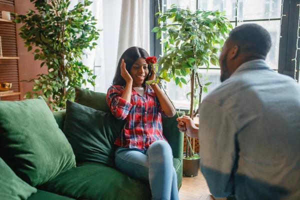 赤いバラのソファに座って 自宅でロマンチックな出会いを持つ若い黒人女性 幸せなアフリカ系アメリカ人女性人のソファの上にリビングルームで — ストック写真