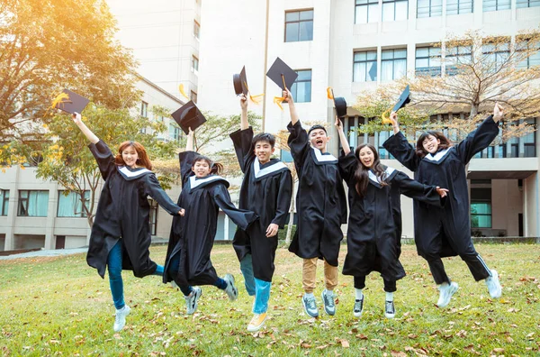 Étudiants Heureux Robes Remise Des Diplômes Célébrant Sautant Sur Campus — Photo