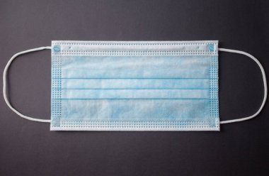 Gri arkaplanda tek kullanımlık yüz maskesi