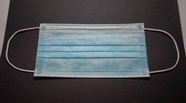 Gri arkaplanda tek kullanımlık yüz maskesi