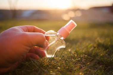 Antiseptik alkol solüsyonu spreyi, kadın elinde hijyenik şişe, koronavirüs konseptini kontrol etmek, kapat.