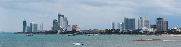 Pattaya Sahili Panorama, Tayland. Kıyı boyunca bulutlu bir gün. Birçok büyük ve modern bina var. Suda çeşitli tekneler görülebilir..